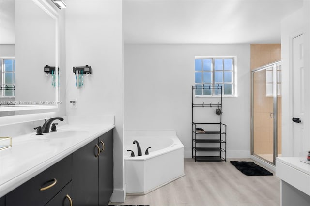 bathroom with hardwood / wood-style flooring, vanity, a healthy amount of sunlight, and independent shower and bath