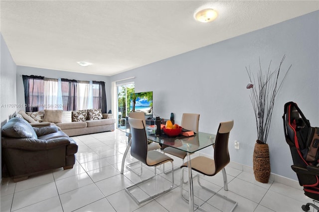 tiled dining space featuring a textured ceiling