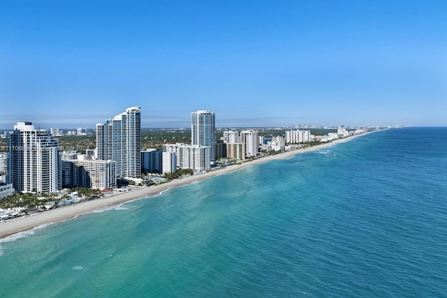 birds eye view of property with a water view and a beach view