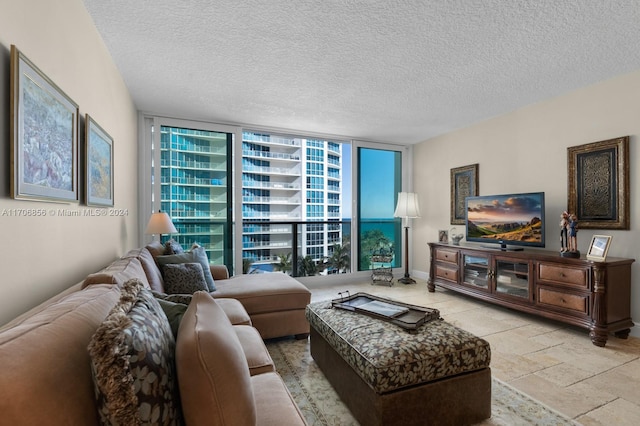 living room with a textured ceiling and a wall of windows