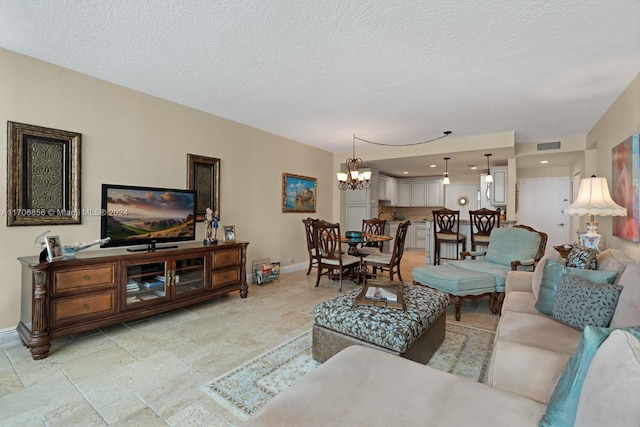 living room featuring a textured ceiling and an inviting chandelier