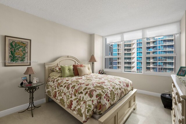 bedroom featuring a textured ceiling and light carpet