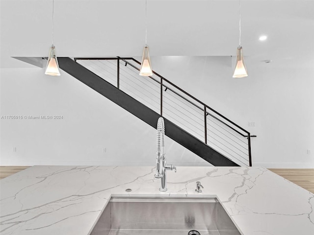 interior details featuring light stone countertops, pendant lighting, and sink