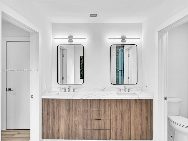 bathroom featuring wood-type flooring, vanity, and toilet