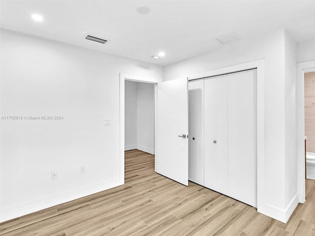 unfurnished bedroom with a closet and light hardwood / wood-style flooring