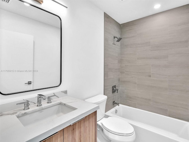 full bathroom featuring vanity, tiled shower / bath combo, and toilet