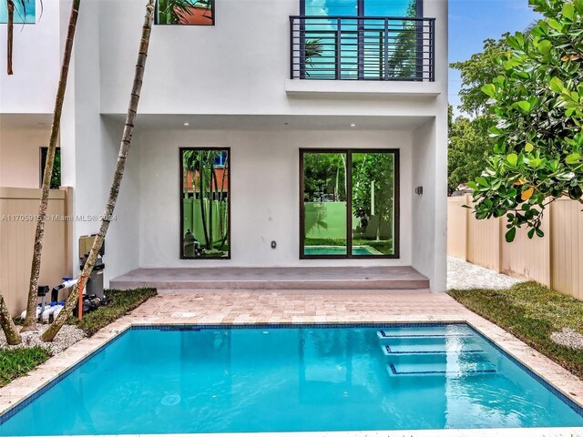 rear view of property with a patio area and a balcony