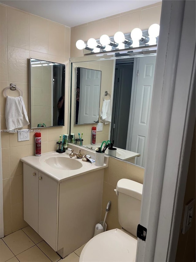 bathroom with tile patterned flooring, vanity, toilet, and tile walls