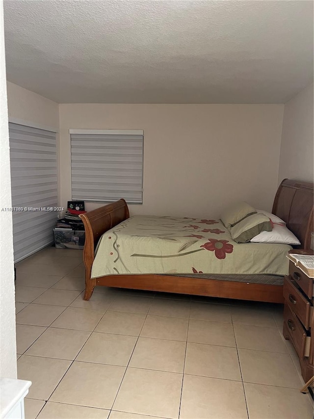 bedroom featuring light tile patterned floors and a textured ceiling