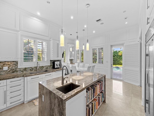 kitchen with a healthy amount of sunlight, sink, and a kitchen island with sink