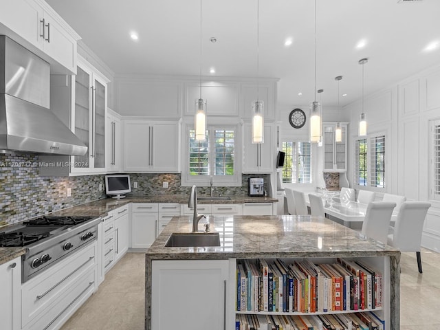 kitchen with stainless steel gas stovetop, a center island with sink, sink, hanging light fixtures, and a healthy amount of sunlight