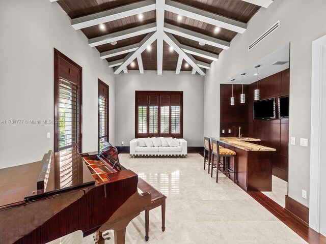 living room featuring beamed ceiling, high vaulted ceiling, wooden ceiling, and a wealth of natural light