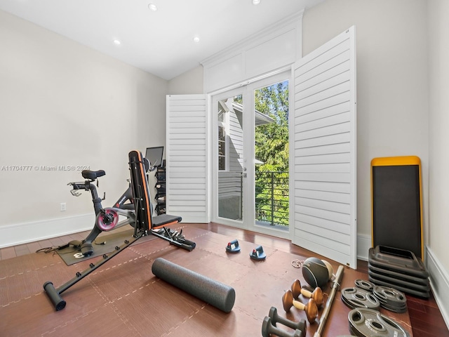 exercise room with hardwood / wood-style floors and vaulted ceiling