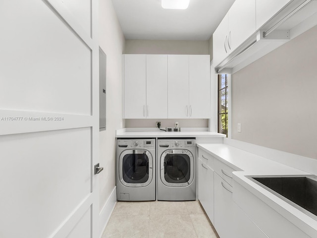 laundry room with washing machine and dryer, sink, light tile patterned floors, and cabinets