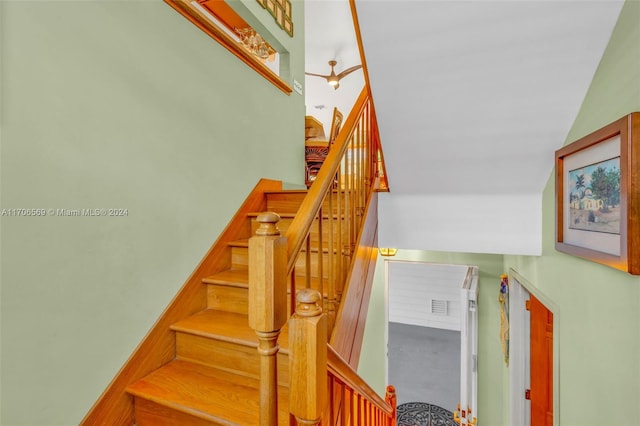 stairway featuring ceiling fan