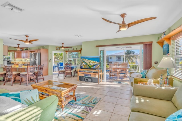 tiled living room with ceiling fan and a wealth of natural light