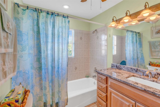 full bathroom with ceiling fan, vanity, shower / tub combo, and toilet