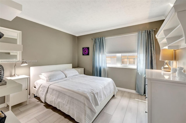 bedroom featuring a textured ceiling, light wood-type flooring, and crown molding