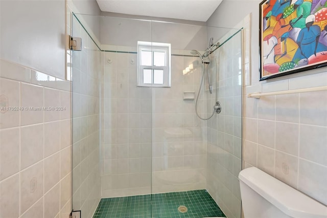 bathroom featuring toilet, an enclosed shower, and tile walls