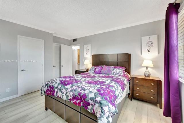 bedroom with light hardwood / wood-style floors, crown molding, a textured ceiling, and a closet