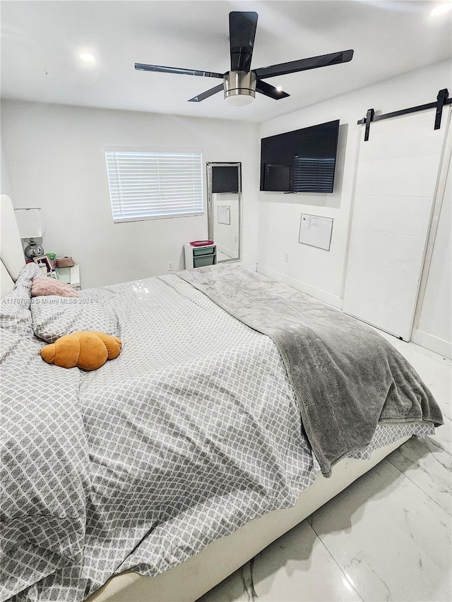 bedroom featuring a barn door and ceiling fan