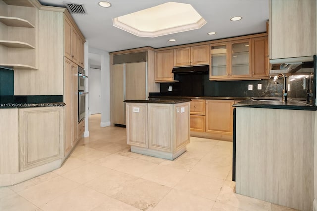 kitchen with double oven, sink, light brown cabinets, light tile patterned floors, and a center island