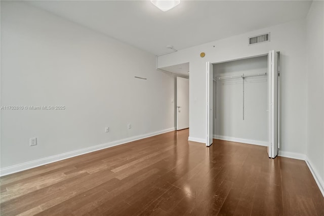 unfurnished bedroom featuring hardwood / wood-style flooring and a closet