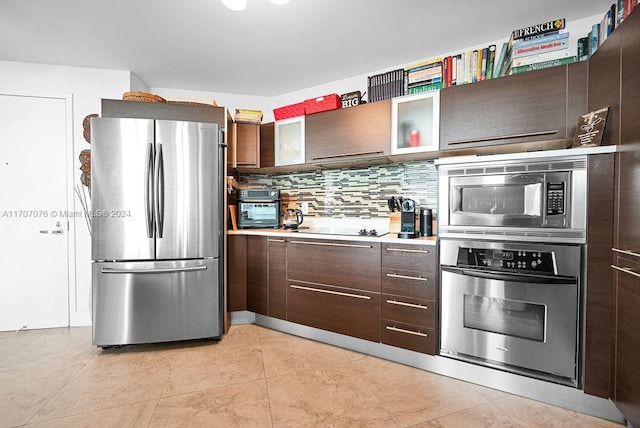 kitchen featuring light tile patterned floors, dark brown cabinetry, appliances with stainless steel finishes, and tasteful backsplash