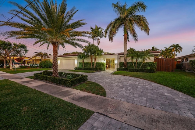 view of front of property featuring a garage and a lawn