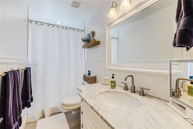 bathroom with toilet, vanity, and wood-type flooring