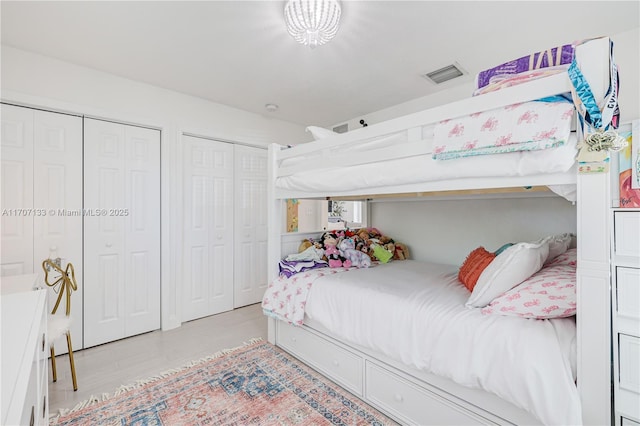 bedroom featuring two closets and light hardwood / wood-style flooring