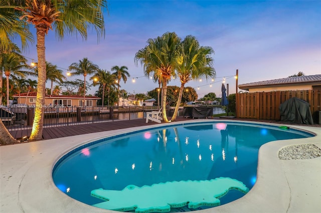 pool at dusk with a deck