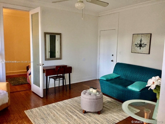 living room with dark hardwood / wood-style floors, ceiling fan, and ornamental molding