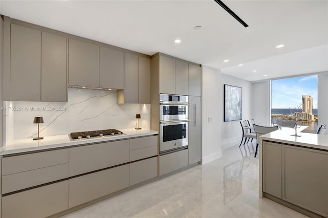 kitchen with gray cabinets, backsplash, and appliances with stainless steel finishes