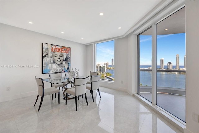 dining space with a water view and floor to ceiling windows