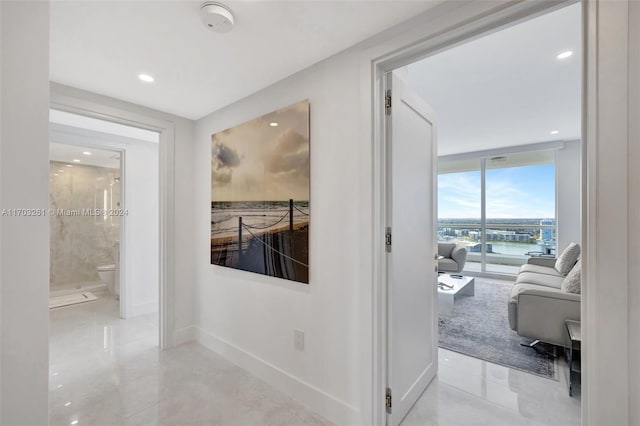 hallway with floor to ceiling windows and a water view