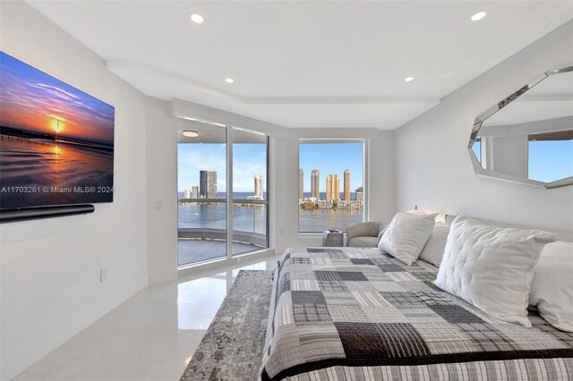 bedroom featuring access to outside, a water view, and multiple windows