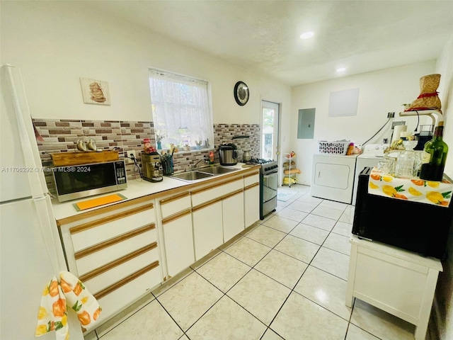 kitchen featuring stainless steel appliances, sink, independent washer and dryer, electric panel, and white cabinetry