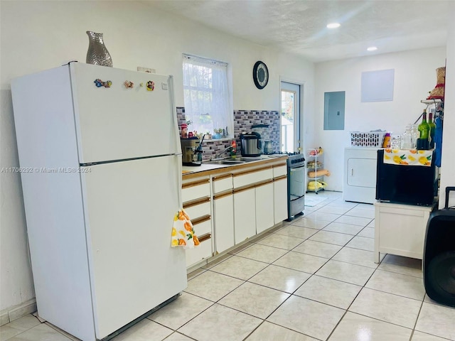 kitchen with gas stove, sink, white refrigerator, washer / dryer, and white cabinets