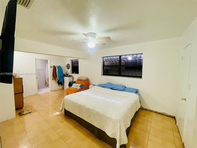 bedroom with connected bathroom, ceiling fan, and light tile patterned floors