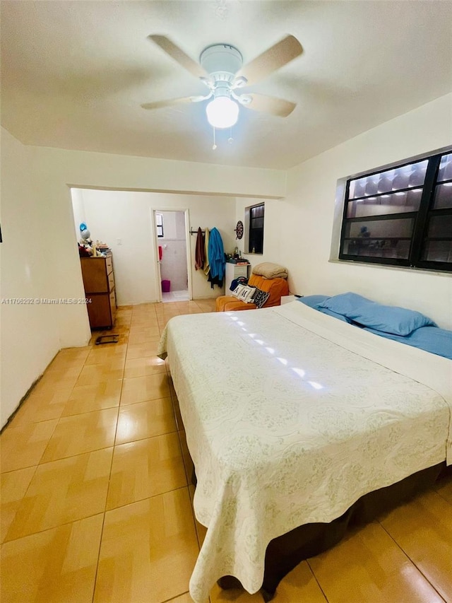 tiled bedroom featuring ceiling fan