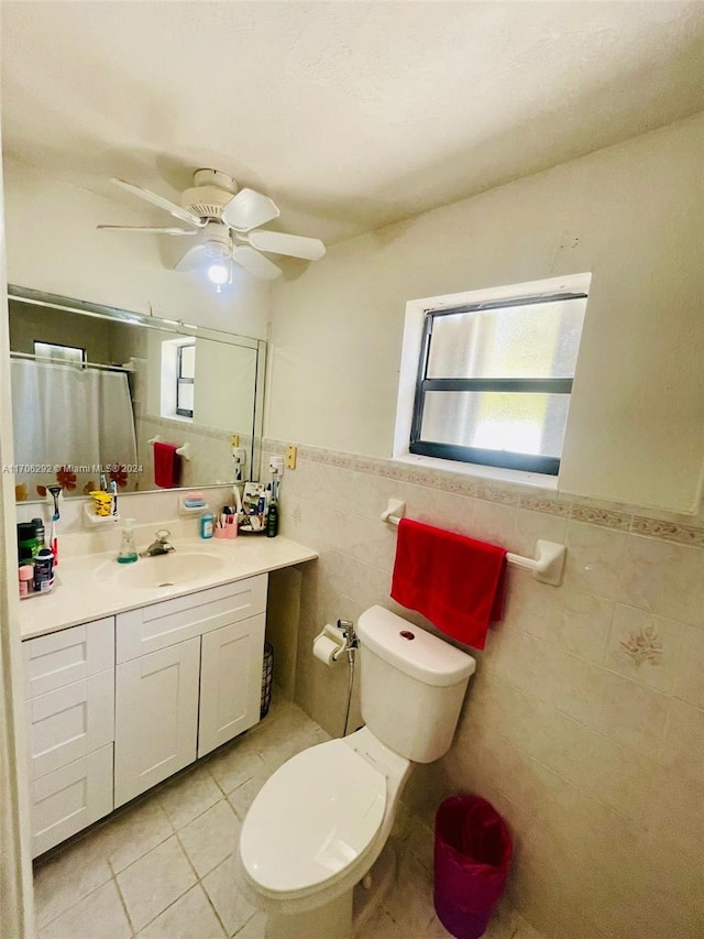 bathroom featuring tile patterned floors, toilet, vanity, tile walls, and a shower with shower curtain