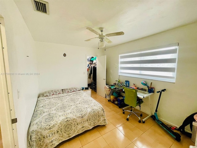 bedroom featuring a spacious closet, a closet, ceiling fan, and tile patterned flooring