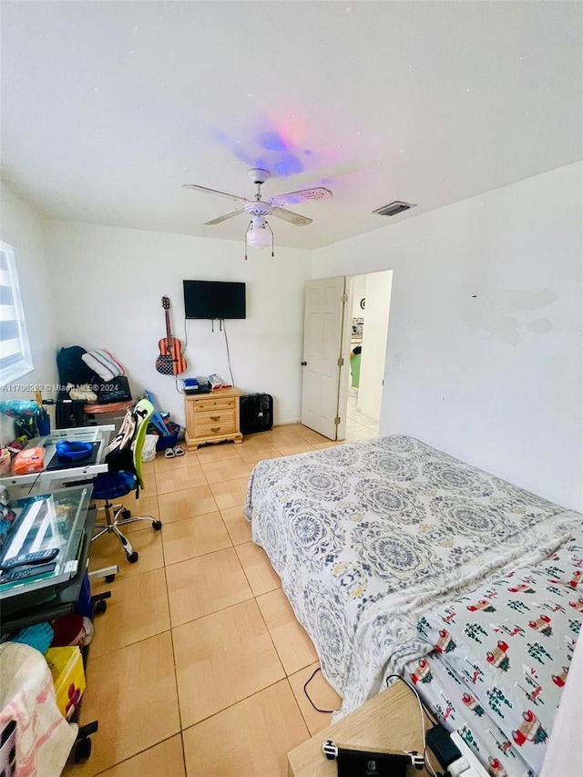 tiled bedroom featuring ceiling fan