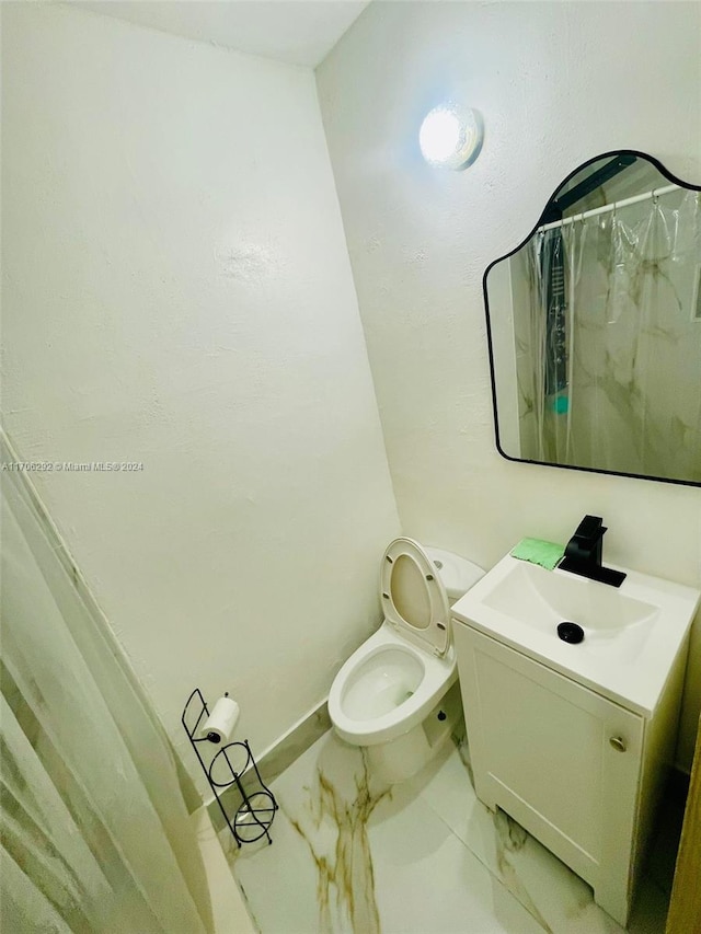 bathroom with vanity, curtained shower, and toilet