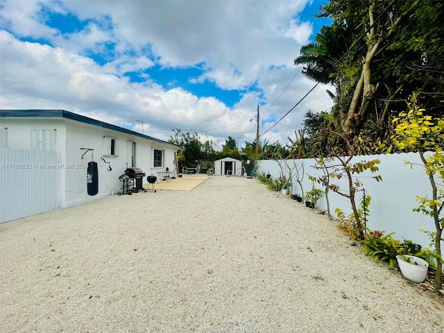 view of yard featuring a shed and a patio