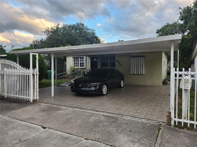 parking at dusk featuring a carport