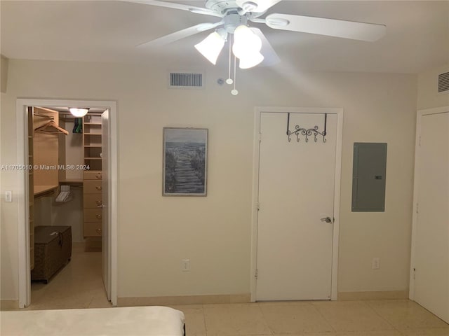 unfurnished bedroom featuring electric panel, ceiling fan, and a spacious closet