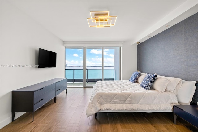 bedroom featuring access to outside, hardwood / wood-style flooring, and floor to ceiling windows