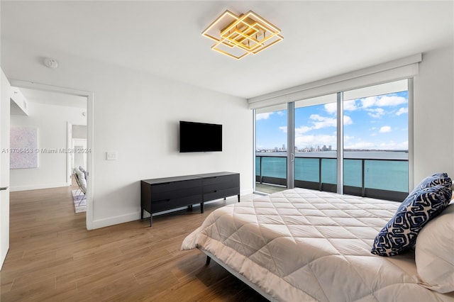 bedroom with access to exterior and wood-type flooring